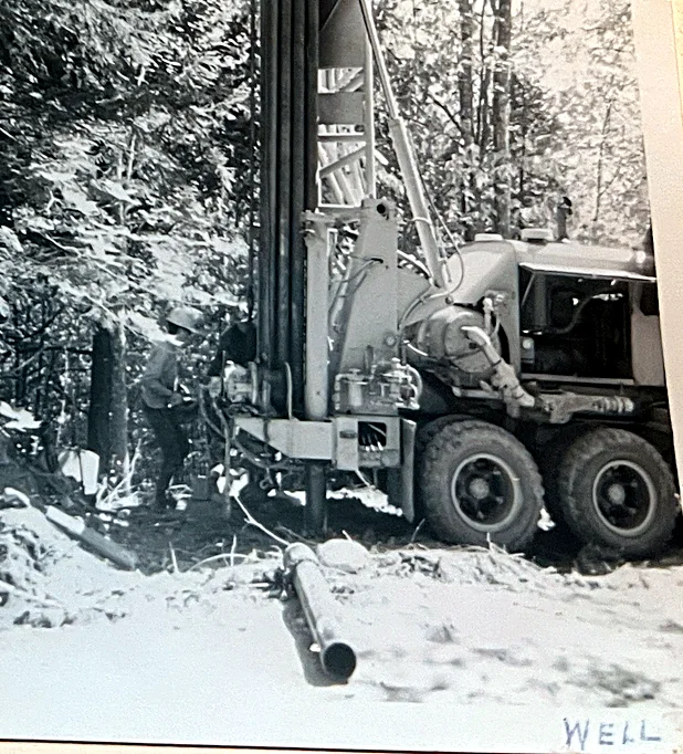 Drilling the well. It went at the top of the driveway for two reasons: the rig couldn’t manage the steep drive, and the next camp out on Lak…